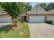 Beautiful townhome with a two-car garage, brick facade, lush lawn, and mature landscaping at 2521 Eden Ridge Ln # 7, Acworth, GA 30101