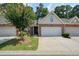 Brick townhome featuring a two-car garage, well-manicured lawn, and mature landscaping at 2521 Eden Ridge Ln # 7, Acworth, GA 30101