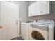 This well-lit laundry room offers ample space, with a washer, dryer and plenty of cabinet space at 2521 Eden Ridge Ln # 7, Acworth, GA 30101