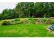Expansive backyard with gentle slope, features stone steps, beautiful landscaping, and a playset at 6040 Boulder Bluff Dr, Cumming, GA 30040
