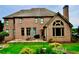 Stately brick home with large windows, patio and well-maintained lawn creating an inviting outdoor space at 6040 Boulder Bluff Dr, Cumming, GA 30040