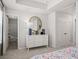 Bright bedroom with white dresser, round mirror and gray carpet at 67 Wilder Ridge Way, Lawrenceville, GA 30044