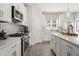 Bright kitchen with stainless steel appliances, white cabinets, and a large center island with seating at 67 Wilder Ridge Way, Lawrenceville, GA 30044