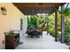 Outdoor patio with a dining table, chairs, grill, string lights, and view of the lush backyard landscaping at 1270 Briarwood Ne Rd, Atlanta, GA 30319