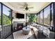 Relaxing screened porch with a stone fireplace, TV, ceiling fan, and comfortable seating for outdoor enjoyment at 1270 Briarwood Ne Rd, Atlanta, GA 30319