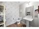 Stylish powder room features patterned wallpaper, pedestal sink, and elegant mirror at 1270 Briarwood Ne Rd, Atlanta, GA 30319