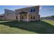 Brick home with a covered patio overlooking a sprawling green lawn at 209 Chiswick Loop, Stockbridge, GA 30281