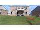 Brick home featuring a covered patio and spacious backyard with green lawn at 209 Chiswick Loop, Stockbridge, GA 30281