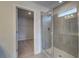 Modern bathroom with walk-in closet and glass-enclosed shower with gray tiling and built-in seat at 209 Chiswick Loop, Stockbridge, GA 30281