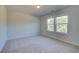 Bedroom featuring neutral walls and carpet, two windows, and ample natural light at 209 Chiswick Loop, Stockbridge, GA 30281