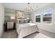 Comfortable bedroom with carpet, large window, stylish light fixture, and accent wall at 209 Chiswick Loop, Stockbridge, GA 30281