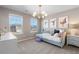 Charming bedroom featuring two windows, artwork and a stylish light fixture at 209 Chiswick Loop, Stockbridge, GA 30281