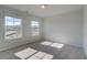 Bright, carpeted bedroom with two windows providing natural light and an open view outside at 209 Chiswick Loop, Stockbridge, GA 30281