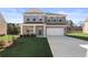 Charming two-story brick home with a well-manicured lawn and attached two-car garage at 209 Chiswick Loop, Stockbridge, GA 30281