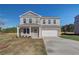 Two-story home with a manicured lawn, two car garage, and beautiful stone and brickwork at 209 Chiswick Loop, Stockbridge, GA 30281