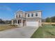 Two-story home with a manicured lawn, two car garage, and beautiful stone and brickwork at 209 Chiswick Loop, Stockbridge, GA 30281