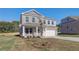 Two-story home with a manicured lawn, two car garage, and beautiful stone and brickwork at 209 Chiswick Loop, Stockbridge, GA 30281