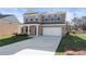 Lovely two-story brick home featuring an attached two-car garage and manicured lawn at 209 Chiswick Loop, Stockbridge, GA 30281