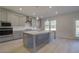 Spacious kitchen with gray cabinets, a large island, stainless appliances, and hardwood floors at 209 Chiswick Loop, Stockbridge, GA 30281