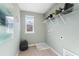 Bright laundry room featuring a window, shelving, and modern washer/dryer at 209 Chiswick Loop, Stockbridge, GA 30281