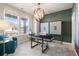Stylish home office featuring a modern desk, elegant chandelier, and ample natural light at 209 Chiswick Loop, Stockbridge, GA 30281