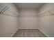 Spacious walk-in closet featuring carpeted floors, neutral walls, and white shelving at 209 Chiswick Loop, Stockbridge, GA 30281