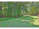 A peaceful and well-manicured backyard offering a serene outdoor space with mature trees at 3131 Lee Cir, Buford, GA 30518
