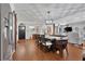 Open concept dining and living area with hardwood floors, updated lighting, and stainless steel refrigerator at 3131 Lee Cir, Buford, GA 30518