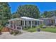 Lovely single-story home with a welcoming front porch, American flag, lush greenery, and a bench at 3131 Lee Cir, Buford, GA 30518