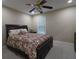 Comfortable bedroom with a ceiling fan, carpet, and floral patterned bedding at 5157 Wellisford Ct, Suwanee, GA 30024