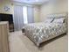 Comfortable bedroom with a patterned bedspread, neutral walls, and window at 5157 Wellisford Ct, Suwanee, GA 30024