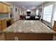 Island with granite countertop, blending seamlessly into the living area at 5157 Wellisford Ct, Suwanee, GA 30024