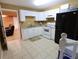 Simple kitchen with white cabinets, standard appliances, and easy access to the basement at 5157 Wellisford Ct, Suwanee, GA 30024