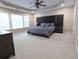 Spacious primary bedroom with tray ceiling, large window, and ample floor space at 5157 Wellisford Ct, Suwanee, GA 30024