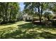A spacious backyard with lush green grass and mature trees shading the house at 1956 Regents Way, Marietta, GA 30062