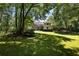 Expansive backyard featuring lush lawn, mature trees, and a deck perfect for entertaining at 1956 Regents Way, Marietta, GA 30062