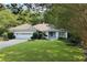 Charming one-story home with a well-manicured lawn, mature trees, and attached two car garage at 1956 Regents Way, Marietta, GA 30062