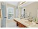 Well-lit bathroom featuring a vanity, sink, mirror, and a window providing natural light at 4177 Elder Ln, Duluth, GA 30096