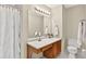 Bathroom featuring a mirror with vanity lighting, modern sink, toilet, and shower with curtain at 4177 Elder Ln, Duluth, GA 30096