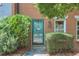 Close up of townhome entrance with charming turquoise front door, flowered wreath, and brick facade at 4177 Elder Ln, Duluth, GA 30096