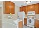 Well-lit kitchen featuring oak cabinets, white appliances, and breakfast bar area at 4177 Elder Ln, Duluth, GA 30096