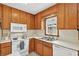 Traditional kitchen featuring wooden cabinets, white appliances, and a bright window at 4177 Elder Ln, Duluth, GA 30096