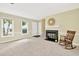 Cozy living room featuring neutral carpet, fireplace, mantel, large windows, and a rocking chair at 4177 Elder Ln, Duluth, GA 30096