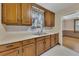 Kitchen featuring stainless steel sink, warm wood cabinets, and views into the next room at 849 N Park Ave, Marietta, GA 30060