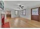View of living room with hardwood floors, a fireplace, a ceiling fan, and doors to adjacent rooms at 849 N Park Ave, Marietta, GA 30060
