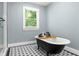 Modern bathroom with black clawfoot tub, decorative tile floor and walk-in shower at 2732 Arbor Se Ave, Atlanta, GA 30317