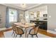 Open-concept dining area with hardwood floors connects to a modern kitchen with a breakfast bar and pendant lighting at 2732 Arbor Se Ave, Atlanta, GA 30317
