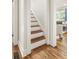 Open staircase featuring hardwood steps and white risers creates an inviting transition between floors at 2732 Arbor Se Ave, Atlanta, GA 30317