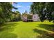 Lush backyard with a screened-in porch, mature trees, and ample space for outdoor activities at 1876 Kathy Ct, Douglasville, GA 30135
