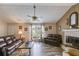 Inviting living room with a fireplace, ceiling fan, large windows and two leather sofas at 1876 Kathy Ct, Douglasville, GA 30135